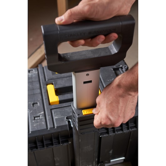 Photo of STANLEY FMST1-75753 toolbox handle being extended, close-up on the push button and hand.