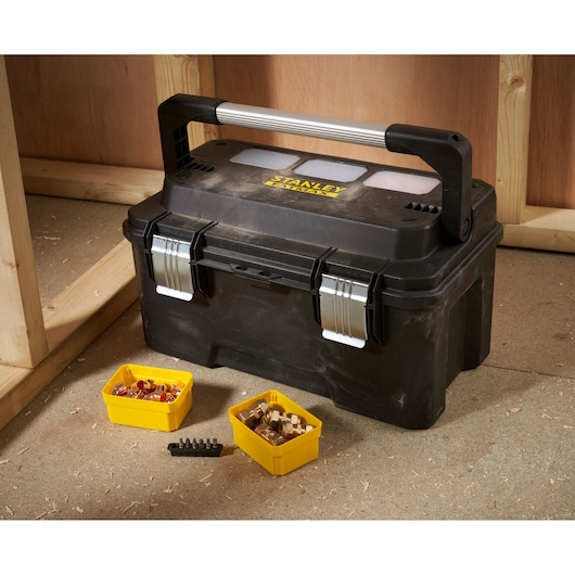 STANLEY FMST1-75792 black toolbox with metal handle, yellow removable tubs and bits, shown in workshop.