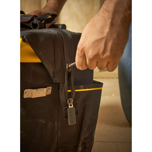 STANLEY FMST1-80148 tool bag with zipper detail and hand using a wrench, close-up photography.