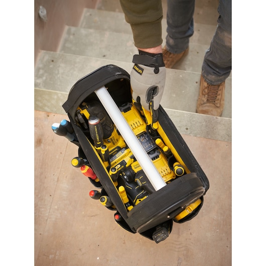 STANLEY FMST17626-1 photography of open tool bag with yellow power tools and hand tools viewed from above.