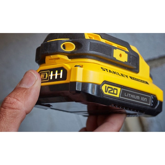 Photo of STANLEY SFMCD711C2K V20 Lithium Ion battery with indicator held by hand.