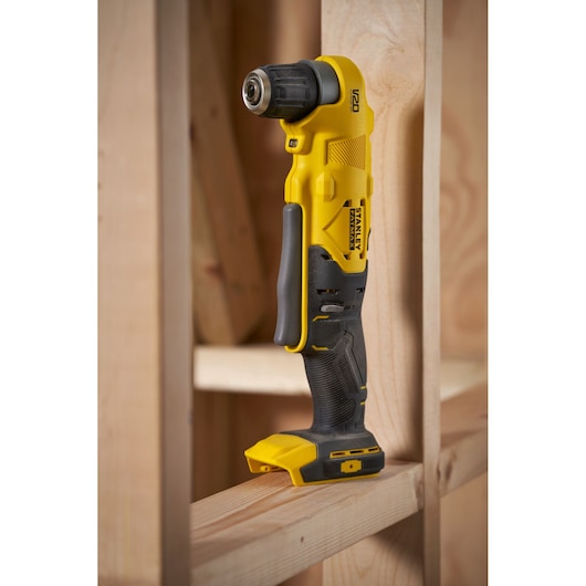 Stanley SFMCD750B cordless right angle drill in yellow and black, side view, displayed on wooden framing.