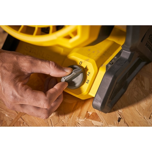 STANLEY SFMCE001B blower speed control knob close-up with hand adjusting settings.