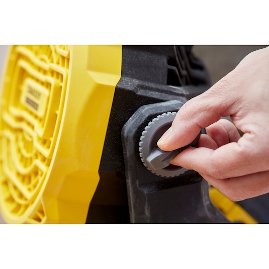 STANLEY SFMCE001B photography of hand adjusting grey knob on yellow and black tool side close-up.