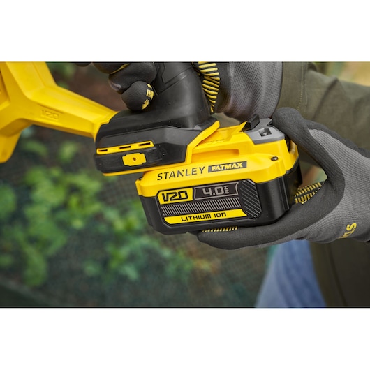 Stanley SFMCGA75M1 V20 Fatmax 4.0Ah Lithium Ion battery close-up in glove-covered hand.