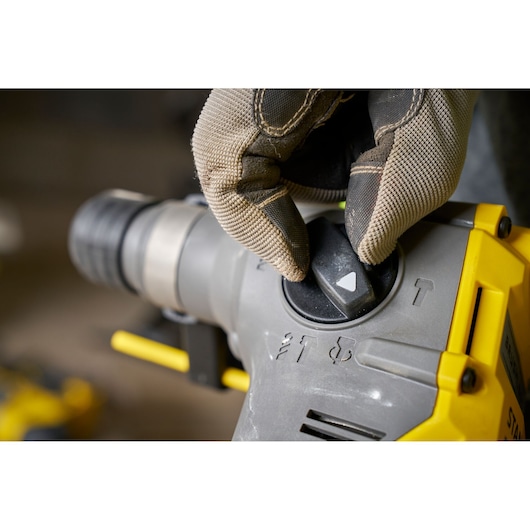 STANLEY SFMCH910M1T rotary hammer control knob close-up, operator wearing work glove.
