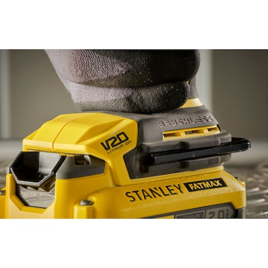 Photo of STANLEY SFMCM300B cordless brushless sander, yellow and black, side angle, in use.