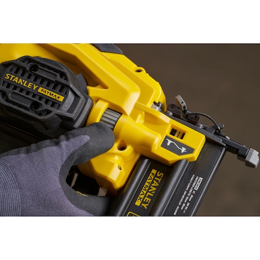 Photo of STANLEY SFMCN618B-XJ nailer tool close-up, yellow and black, showing adjustment dial and branding.