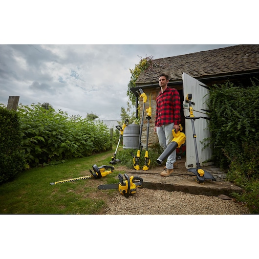 Stanley SFMCPS620B garden power tools displayed outdoors near a house, various yellow and black tools shown.