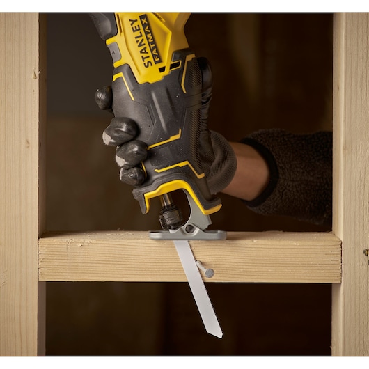 STANLEY SFMCS310B reciprocating saw cutting wood with exposed nail, close-up in use.