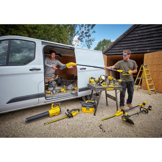 STANLEY SFMCSTB933M power tools displayed outdoors near white van and table with multiple yellow tools.