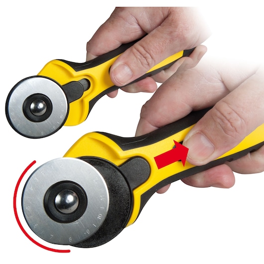 STANLEY STHT0-10194 rotary cutter with yellow and black handle, close-up of hand operating safety mechanism, front angle.