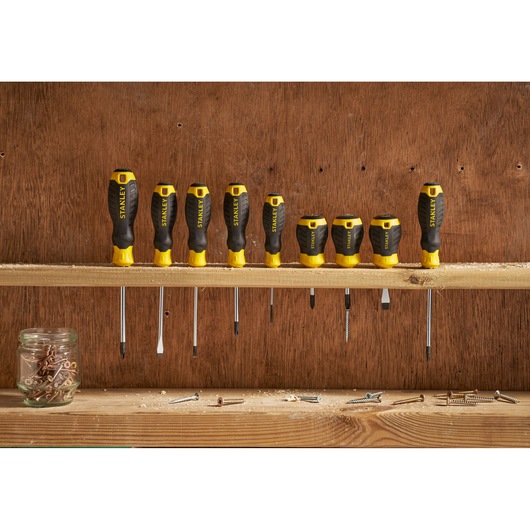 Photo of STANLEY STHT16153-0 screwdriver set, eight black and yellow screwdrivers on a wooden shelf.