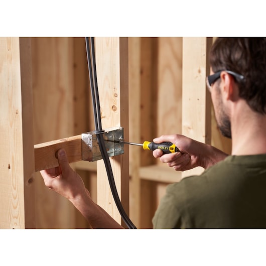 STANLEY STHT16155-0 screwdriver used on metal electrical box in wooden frame construction.