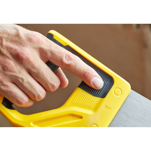 Photo of STANLEY STHT20355-1 saw handle close-up with finger pressing black ridged button, yellow and black design.
