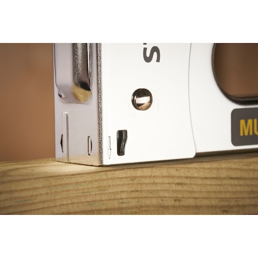 STANLEY STHT6-70410 stapler close-up photo showing metal body and trigger, placed on wood, left angle.