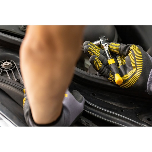 STANLEY STMT82663-0 ratchet wrench held in gloved hand, close-up, automotive repair context.