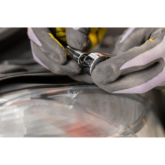 STANLEY STMT82663-0 ratchet being used with gloves near a car headlight, close-up photography.