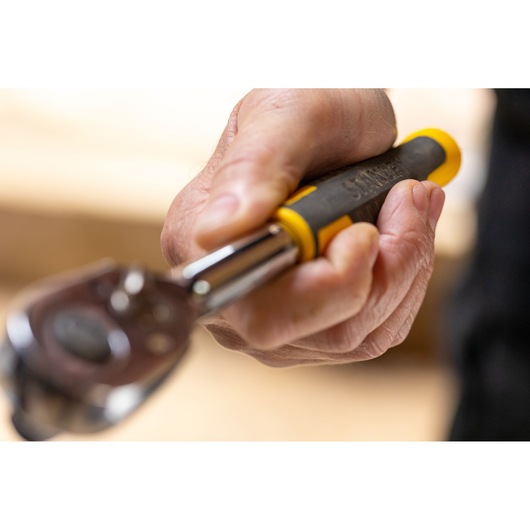 STANLEY STMT82664-0 ratchet wrench with black and yellow handle, handheld, close-up view.