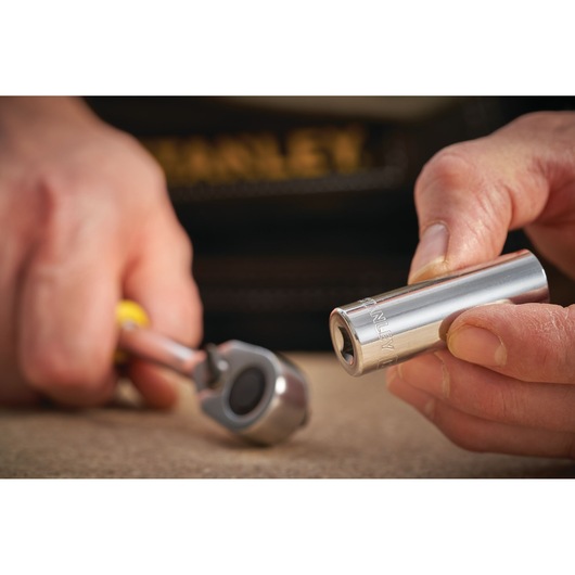 Photo of STANLEY STMT86099-0 socket with ratchet handle, close-up on hand holding socket.