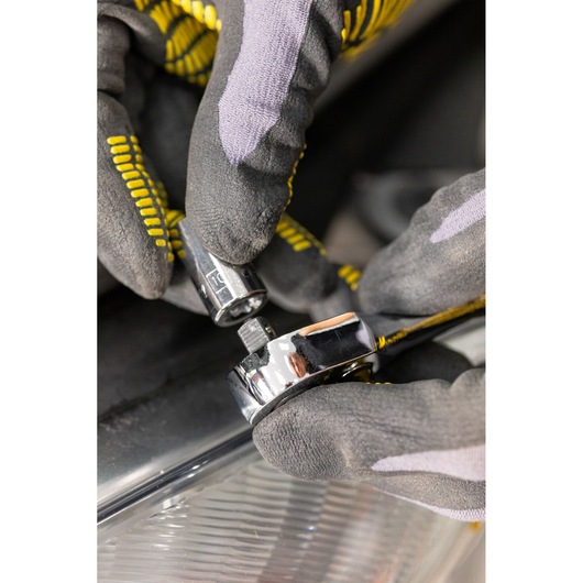 STANLEY STMT86107-0 ratchet and socket held by gloved hands, close-up angle, photography product.