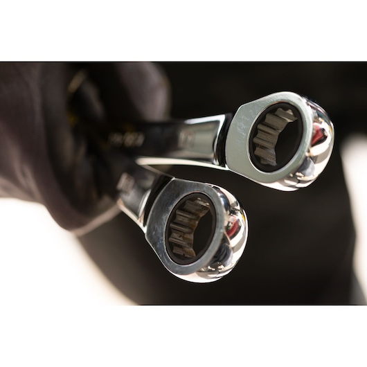 STANLEY STMT89909-0 photography of two chrome ratcheting wrenches held in a gloved hand, close-up view.