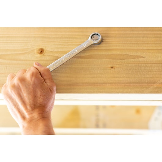 Photo of STANLEY STMT95789-0 ratcheting wrench used on a wood surface, close-up angle.
