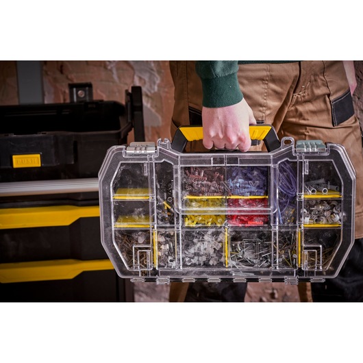 STANLEY STST1-79231 organiser with yellow handle, clear lid, assorted hardware compartments, carried by hand.