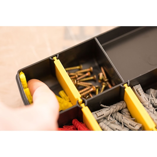 STANLEY STST81680-1 organizer box with yellow dividers, storing screws and wall plugs, close-up angle.