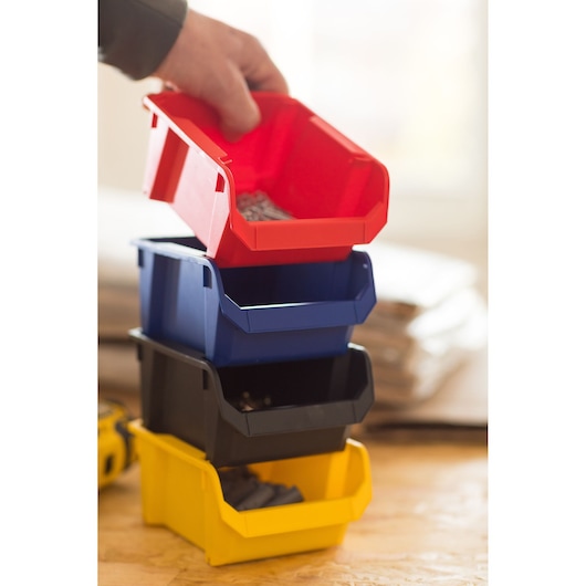 STANLEY STST82736-1 photography showing a hand lifting a red storage bin from a stack of multicolor plastic bins.