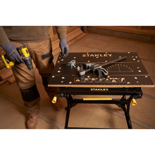 STANLEY STST83800-1 workbench top view with tools and screws, photo in workshop setting.